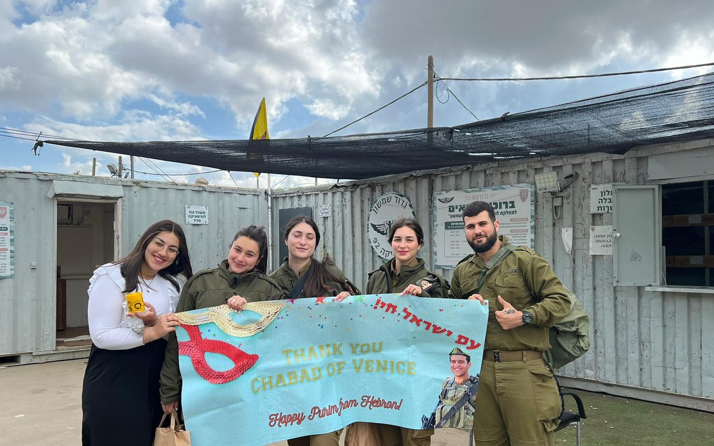IDF soldiers holding a hand-painted banner reading 'Thank you Chabad of Venice — Happy Purim from Israel'