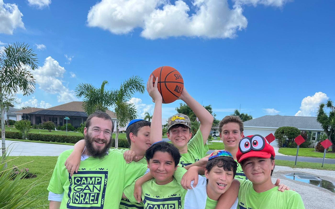 Camp Gan Israel campers and counselors in green camp shirts on a trip day