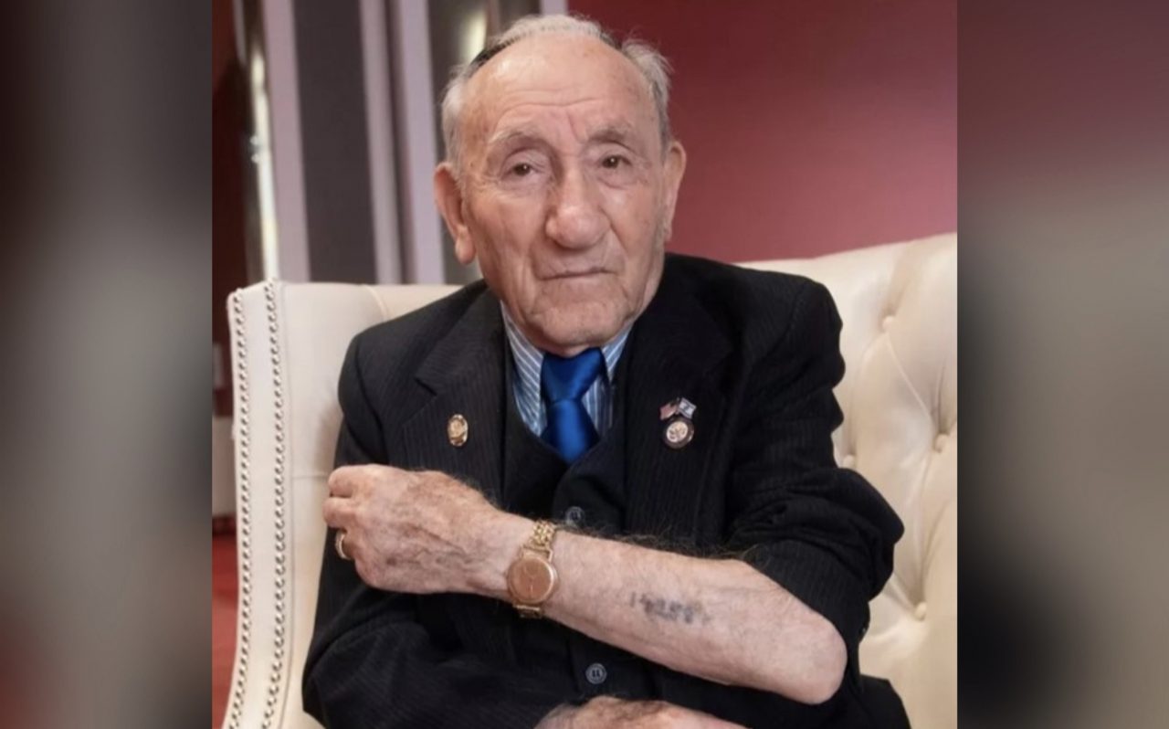 Joe Alexander seated, his concentration camp number visible on his forearm