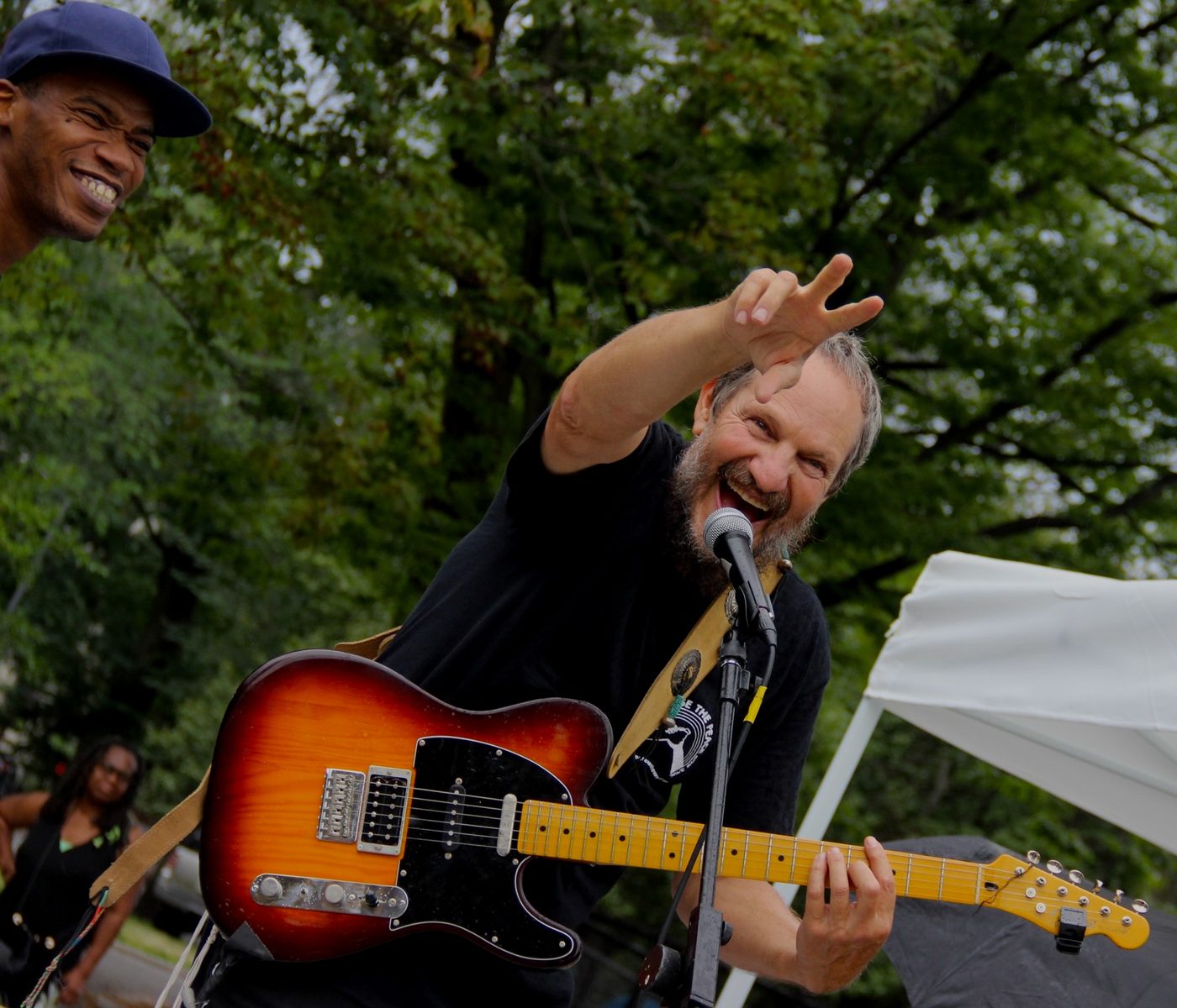 Dr. Laz performing with his guitar, mid-song