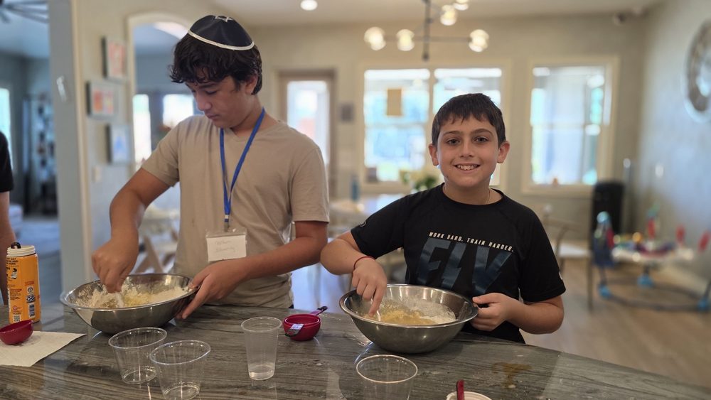 Two teens cooking at the counter