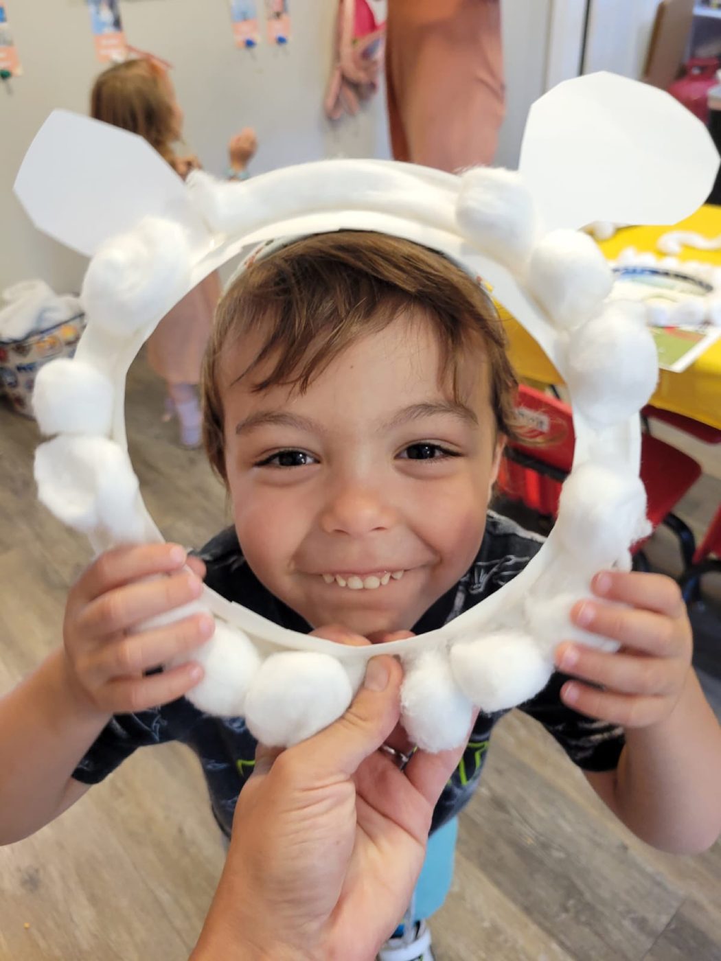 A Hebrew School student holding up a cotton-ball craft