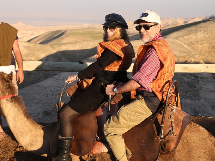 Trip participants riding camels in the Judean desert