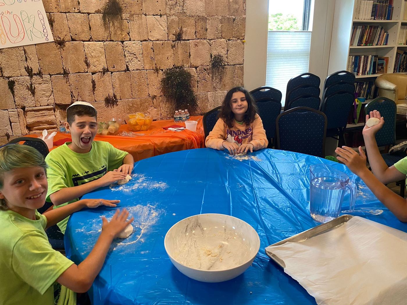 Children rolling dough at the model matzah bakery